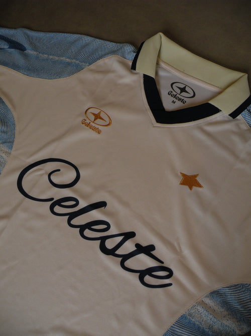 Maillot de Football Celeste avec col. Bleu ciel, beige crème et doré. Numéro 7. Logo brodé.