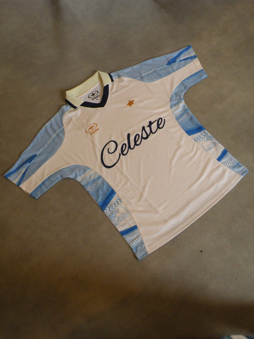 Maillot de Football Celeste avec col. Bleu ciel, beige crème et doré. Numéro 7. Logo brodé.
